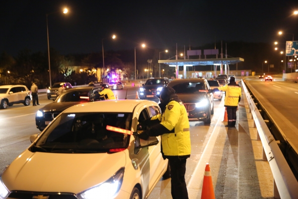 특별 음주운전 단속에 투입된 경찰이 고속도로 출구에서 운전자들을 상대로 음주 여부를 측정을 하고 있다.