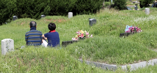 민족 대명절 추석이 약 3주 앞으로 다가온 25일 경기 파주시 용미리 묘지에서 성묘객들이 성묘를 한 뒤 휴식을 취하고 있다.