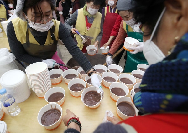 절기상 동지(冬至)인 22일 오전 서울 종로구 조계사에서 열린 팥죽 나눔행사에서 자원봉사자들이 밭죽을 나눠주고 있다.