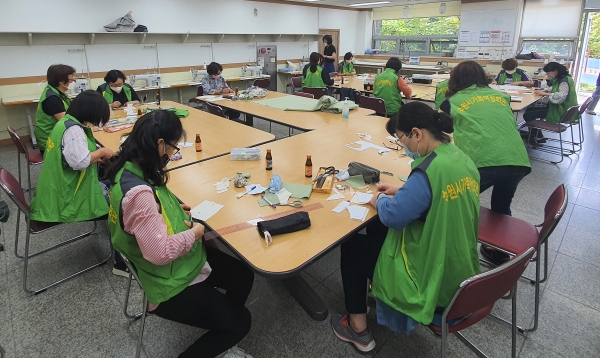 ▲ 수원시가족여성회관의 봉사자들이 여름철 면마스크를 제작하는 봉사에 참여하고 있다.