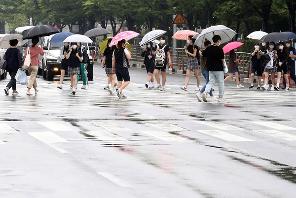 ▲ 본격적인 장마가 시작된 24일 오후 인천시 남동구 터미널사거리에서 시민들이 우산을 쓰고 도로를 건너가고 있다.