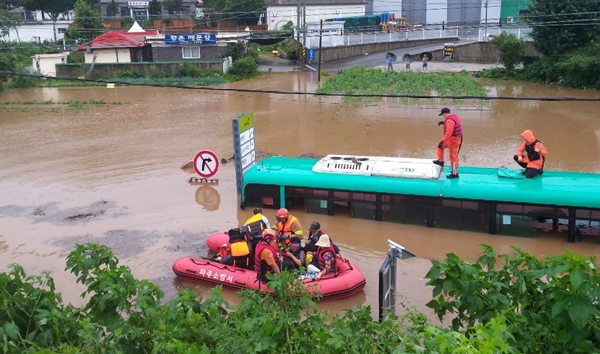 6일 오전 경기 파주시의 한 도로에서 시내버스가 물에 잠겨 구조 대원들이 승객들을 구조하고 있다.    (사진=파주소방서 제공)