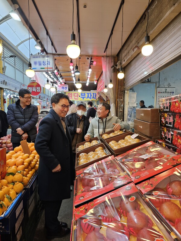 홍성관 소사구청장과 간부 공무원이 청과물 점포에서 상품을 구매하며 상인을 격려하고 있다